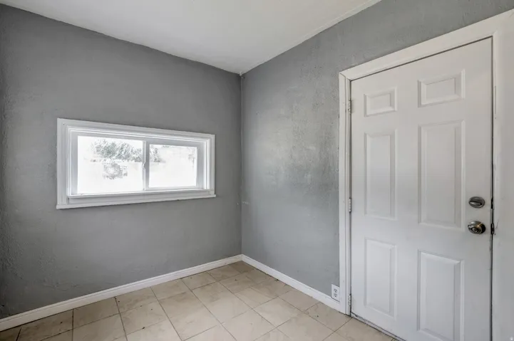 Room featuring neutral gray walls and light-toned floor tiling