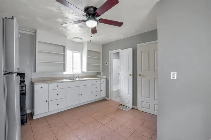 Kitchen featuring white cabinetry, light-toned countertops, and a stainless steel refrigerator