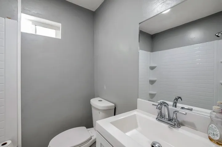 Bathroom featuring a white subway tile shower surround with integrated shelving