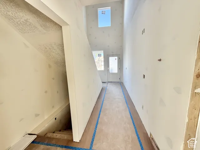 Two-story entryway with a transom window and wood-finish flooring