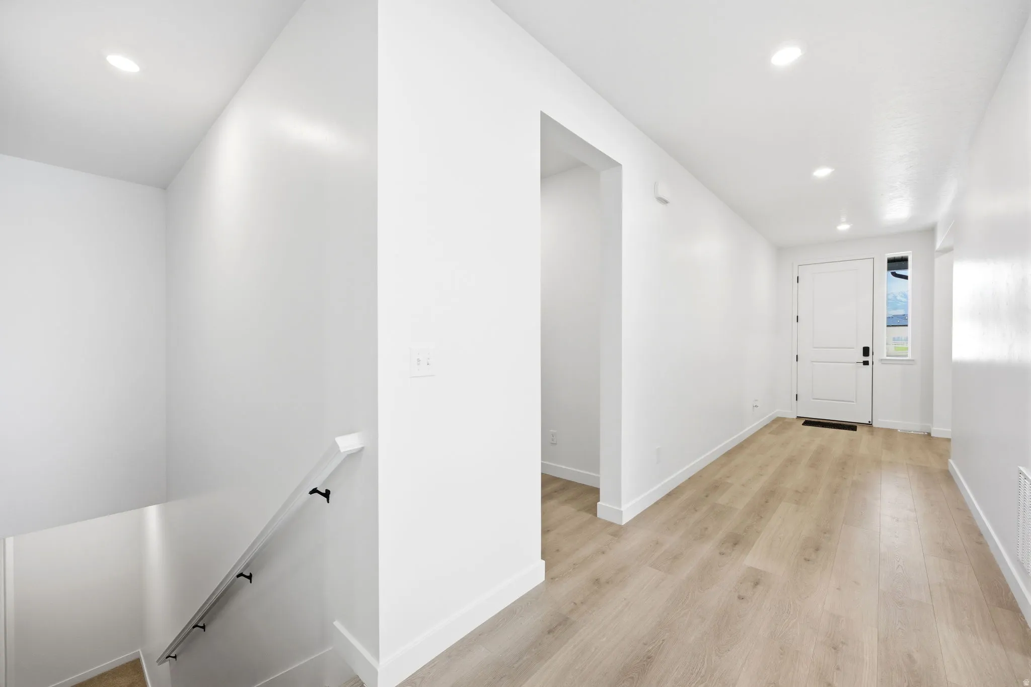 Entryway featuring light wood-finish flooring and recessed ceiling lighting