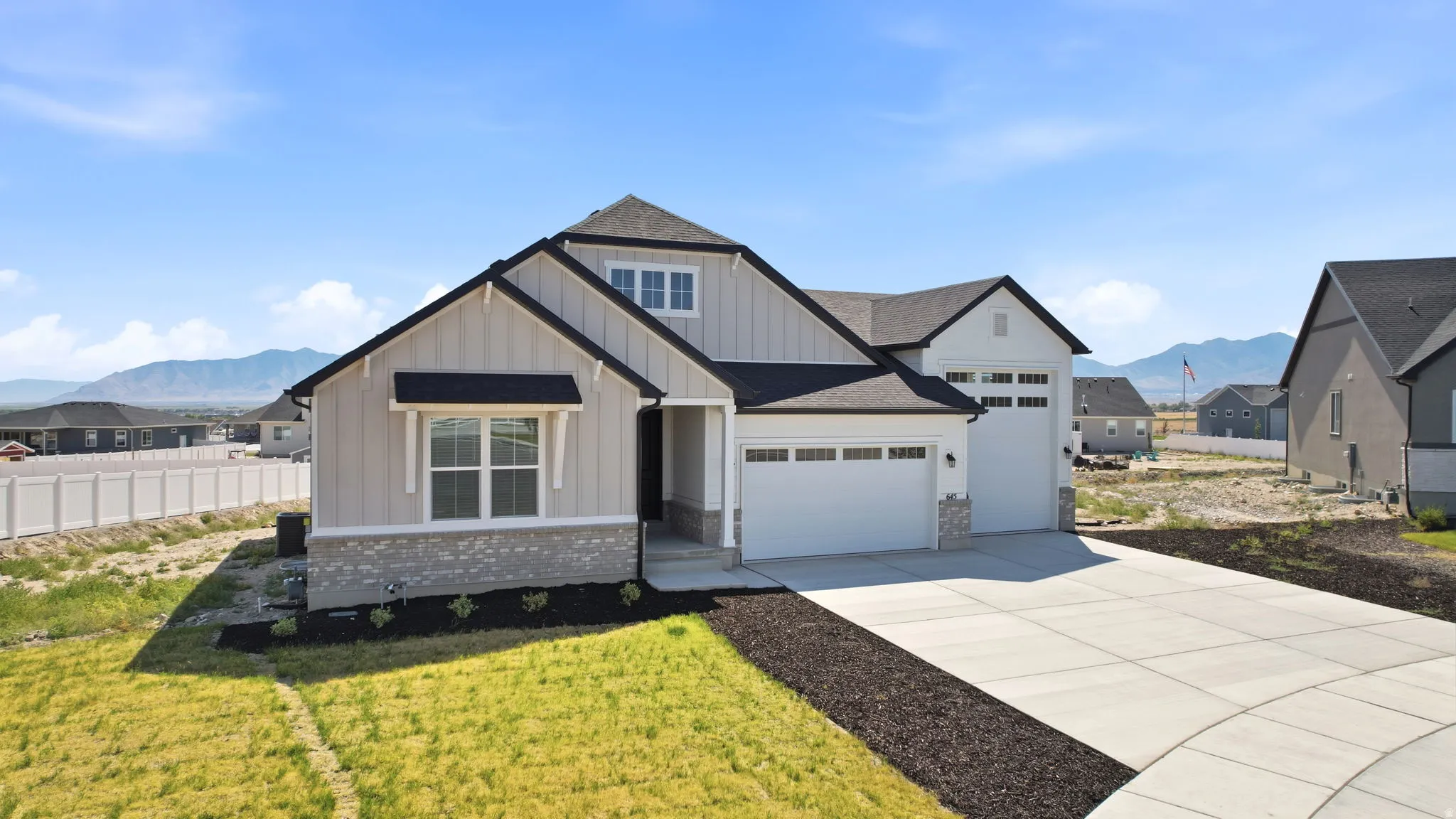 Contemporary residence featuring light-colored vertical siding and stone veneer accents