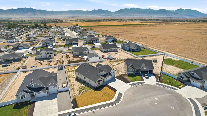 New construction residences situated on a cul-de-sac, featuring dark shingle roofing, attached two-car garages, and concrete driveways