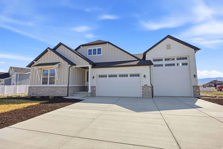 Contemporary ranch-style residence featuring a two-tone exterior, stone veneer accents, and a covered entry