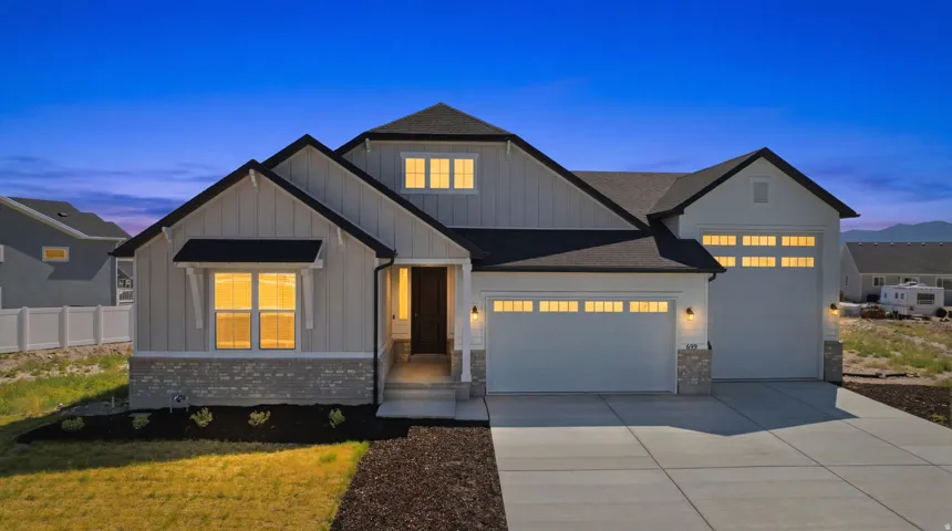 Contemporary single-story residence featuring a two-car garage, board and batten siding, and stone accents