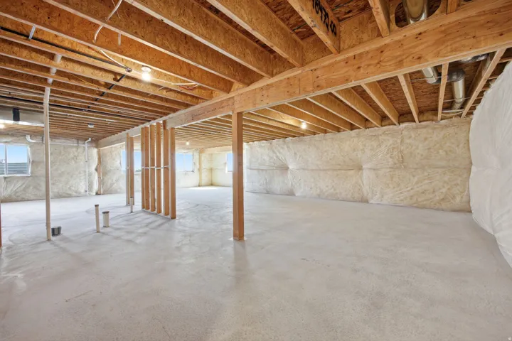 Unfinished basement with concrete flooring and visible insulation