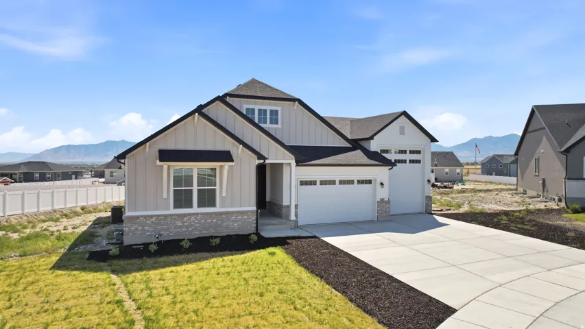 Contemporary residence featuring light-colored vertical siding and stone veneer accents