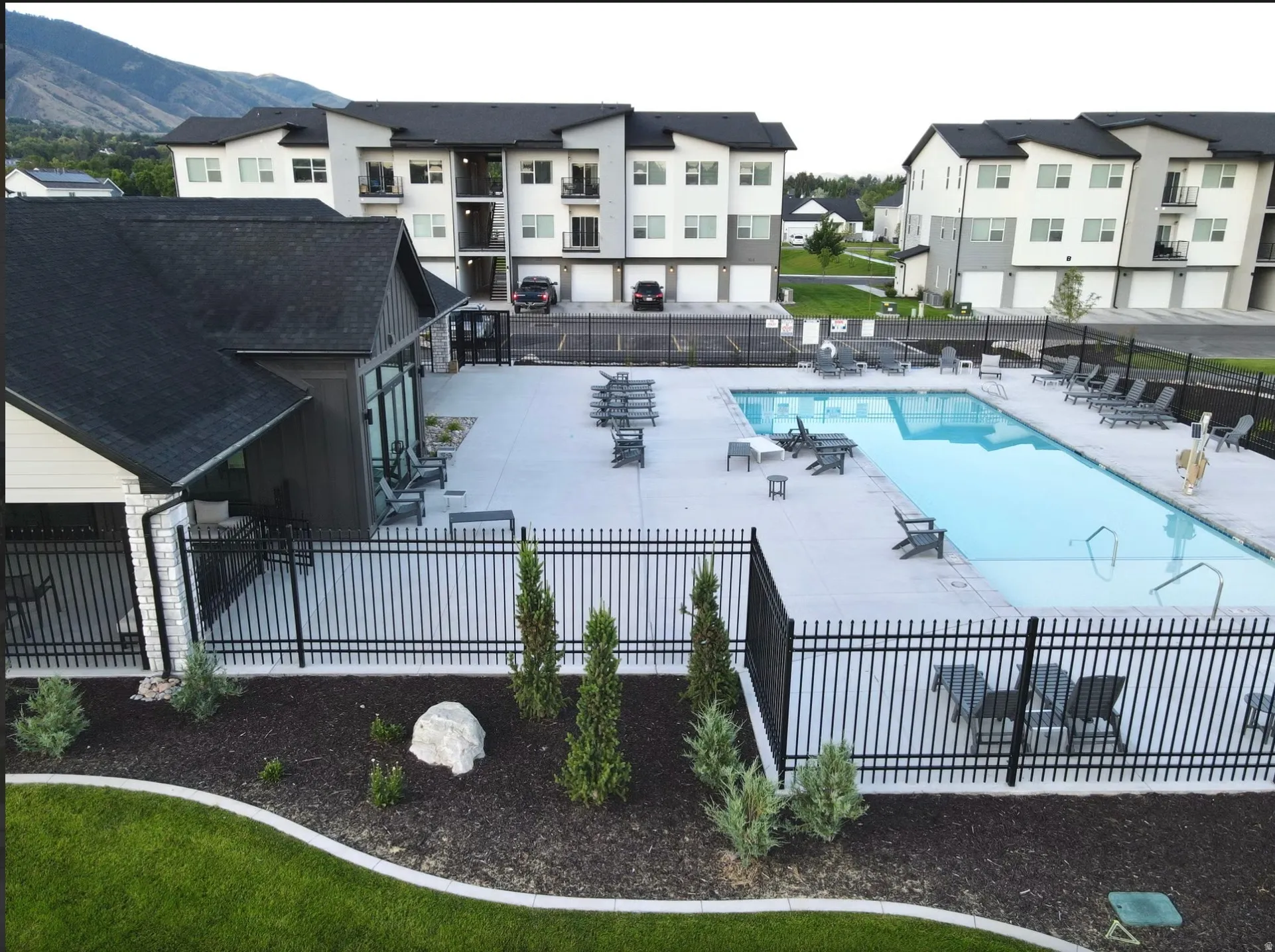 Outdoor swimming pool surrounded by a concrete deck with lounge seating