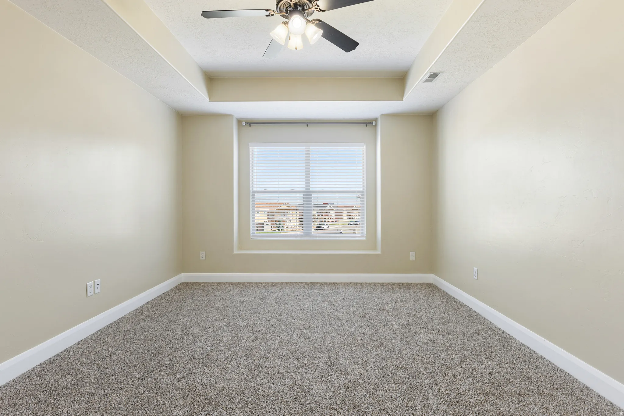 Room featuring neutral carpeting, light-toned wall paint, and a ceiling fan with integrated lighting