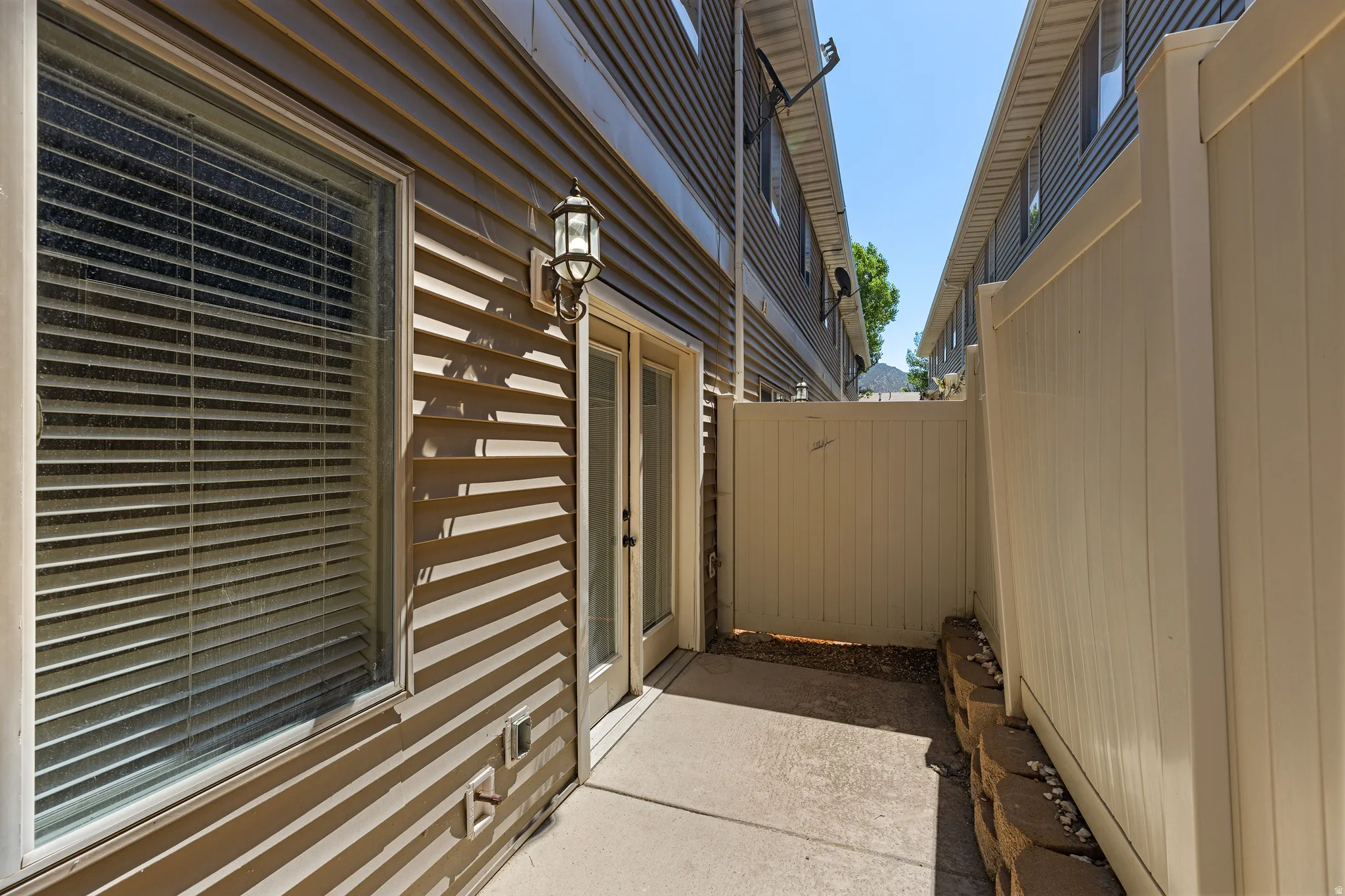 Private patio space featuring concrete flooring and a privacy fence