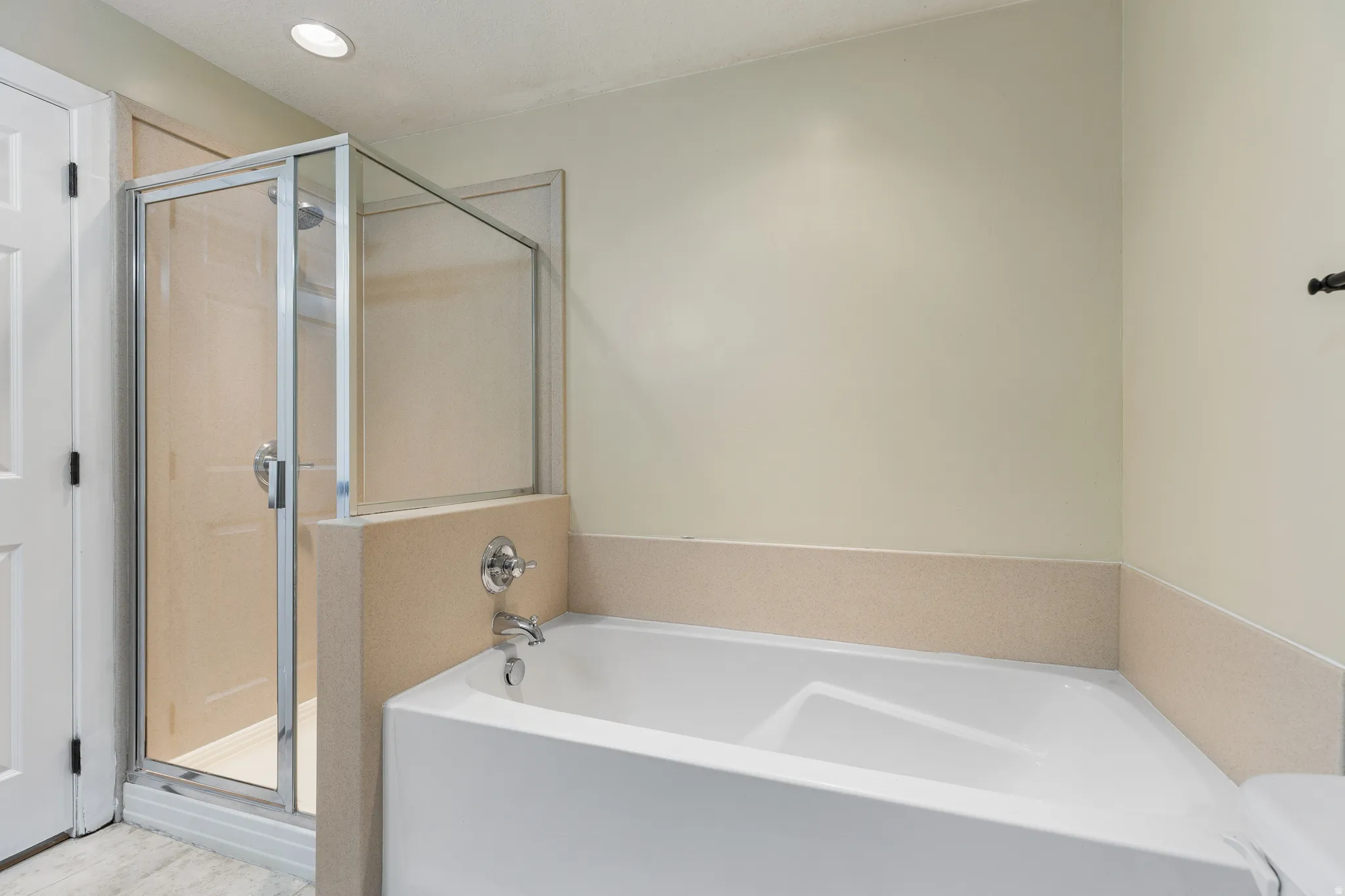 Alcove bathtub with deck-mounted chrome faucet, set against a light-toned wall