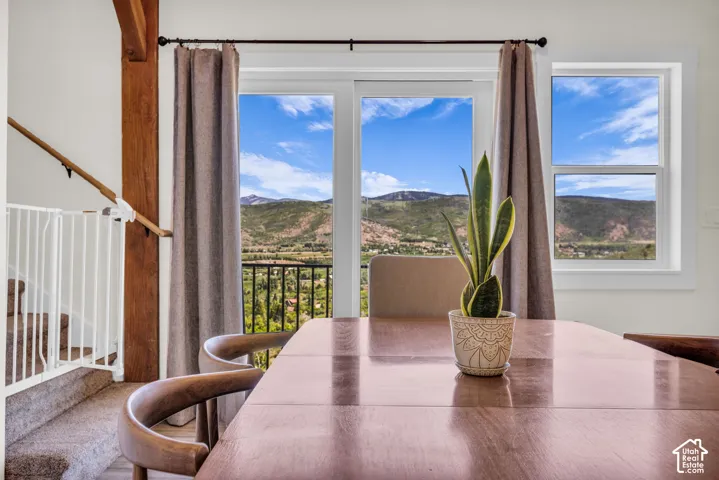 Sliding glass door opening to a balcony with mountain and valley scenery