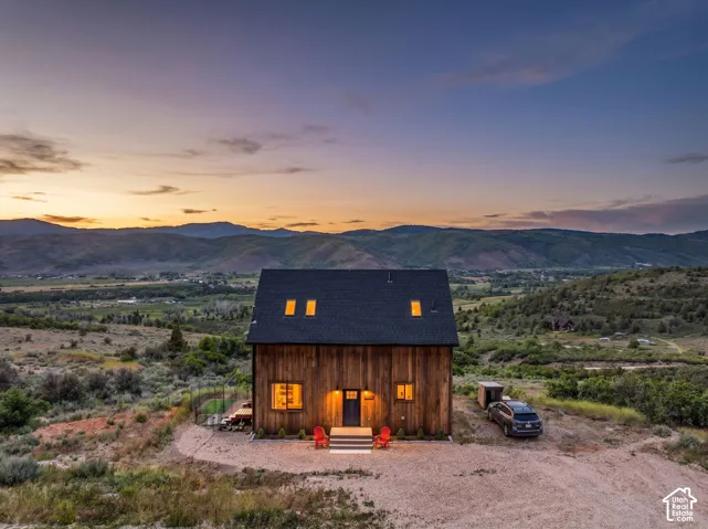 Modern farmhouse exterior featuring vertical wood siding, a dark roof, and multiple windows