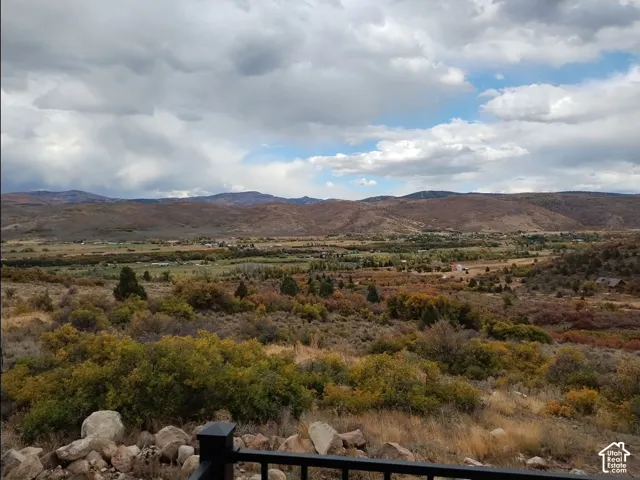 Expansive mountain and valley landscape featuring a varied autumn color palette