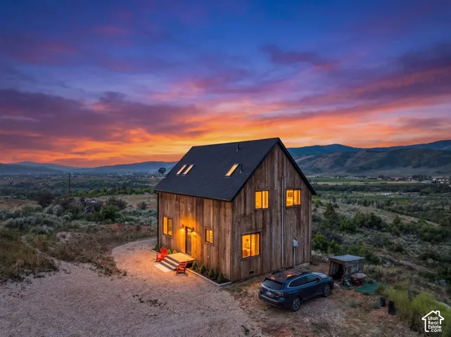 Rustic wood-sided dwelling featuring an asymmetrical gabled roofline with skylights