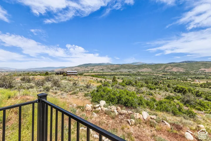 Expansive landscape featuring distant mountains and a valley with lush vegetation