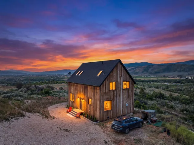 Rustic wood-sided dwelling featuring an asymmetrical gabled roofline with skylights