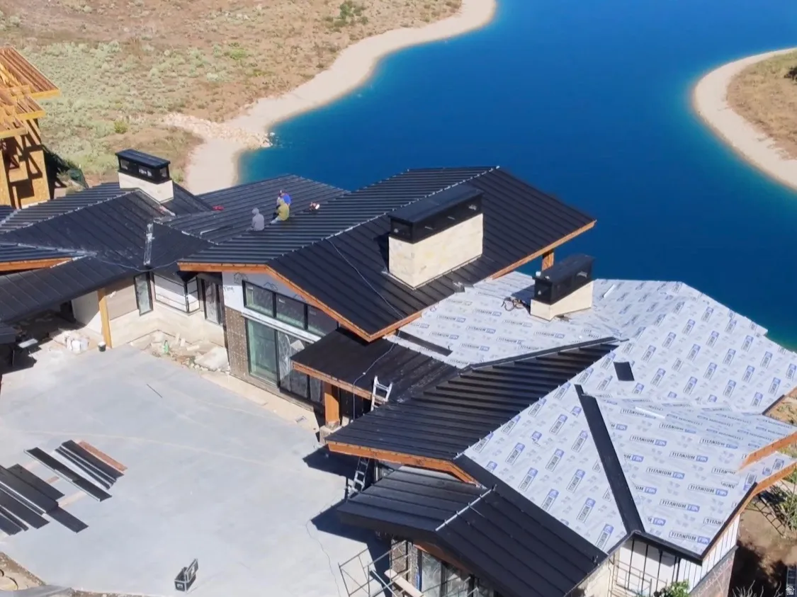 Drone pic with roof, exterior, and pond