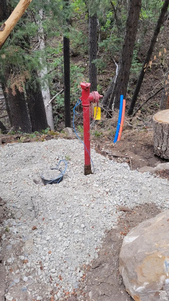 Red standpipe with a yellow tag set on a gravel base