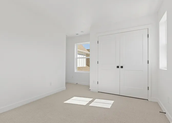 Interior room featuring light-toned carpet flooring, white walls, and bright white trim