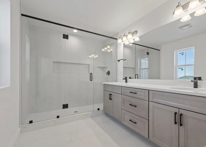 Spacious bathroom featuring a glass-enclosed shower with tiled walls and a built-in niche
