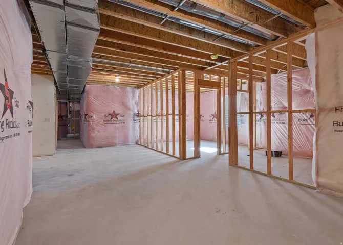 Unfinished basement with concrete flooring, exposed wood framing, and overhead ductwork