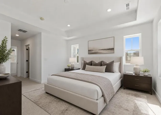 Virtually staged owners suite with recessed lighting, tray ceiling, twin windows, and carpeted flooring