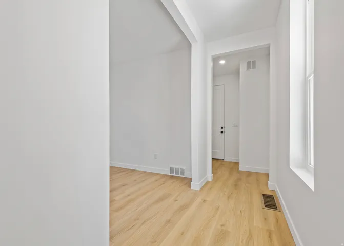 Entryway featuring wood-finish flooring, crisp white walls, and a recessed window