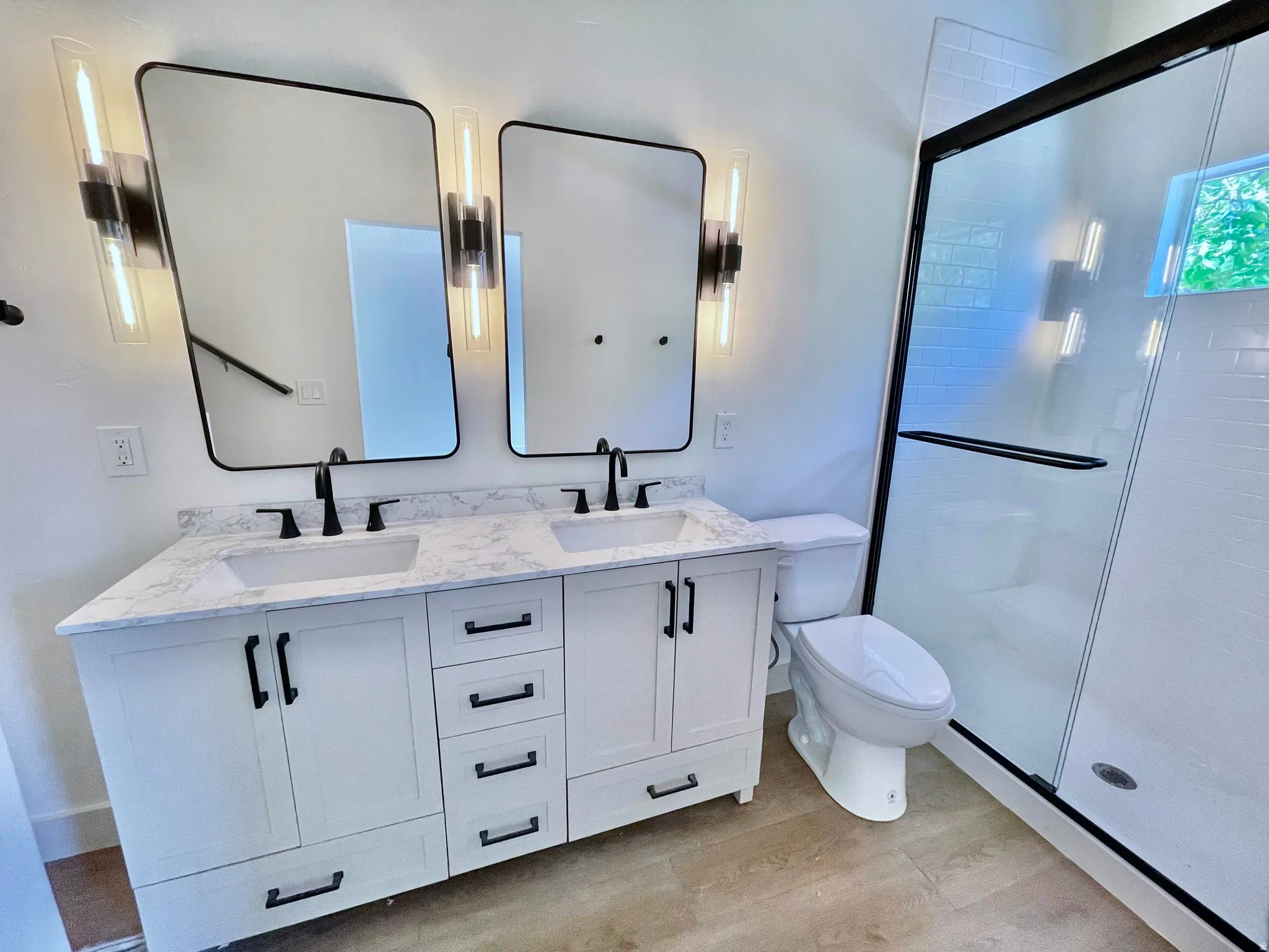 Dual vanity with white cabinetry and integrated sinks, complemented by a stone-finish countertop