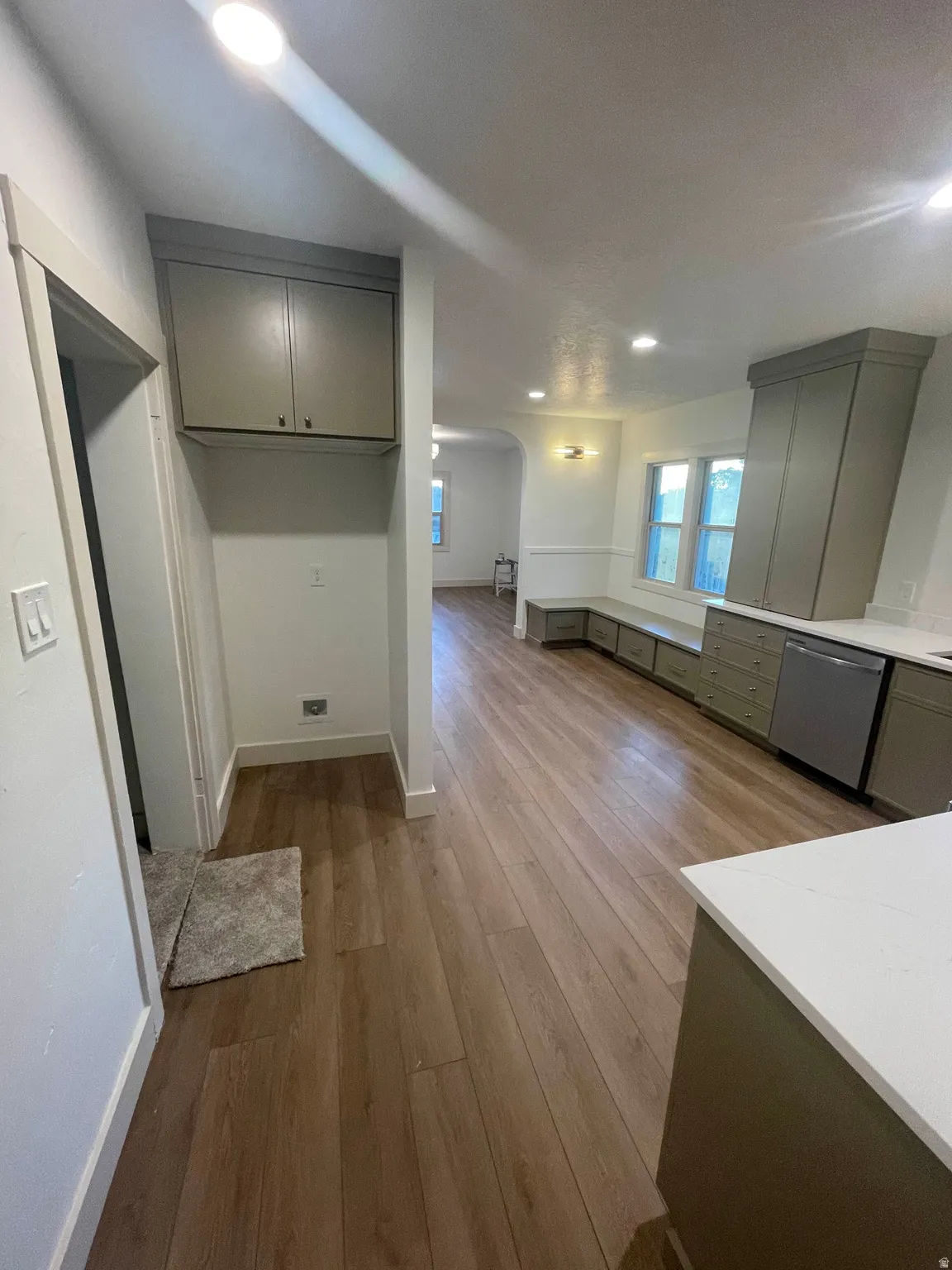 Open-concept living space with wood-finish flooring, recessed lighting, and expansive windows