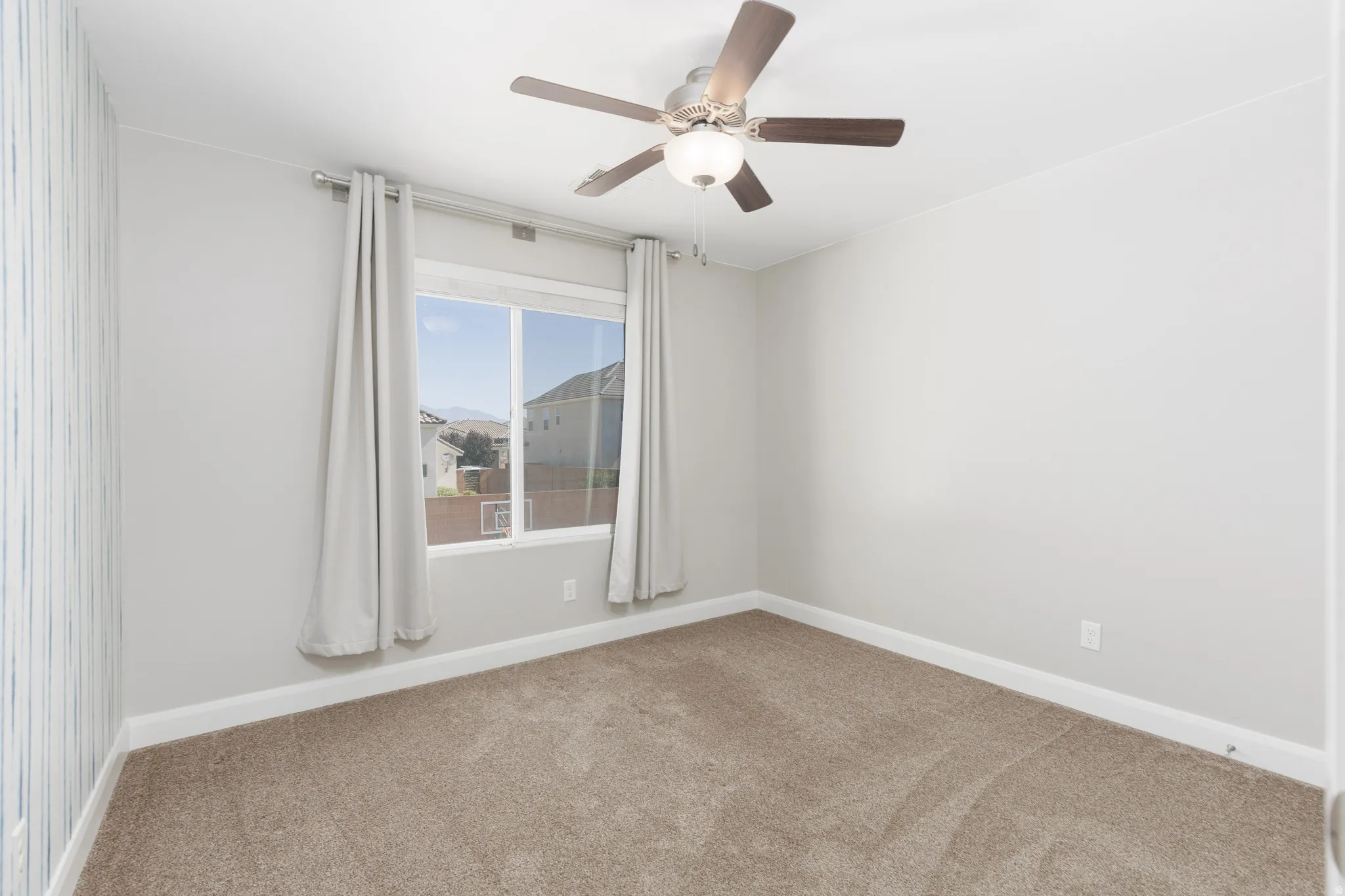 Room featuring neutral-toned carpeting, light gray wall paint, and white baseboards