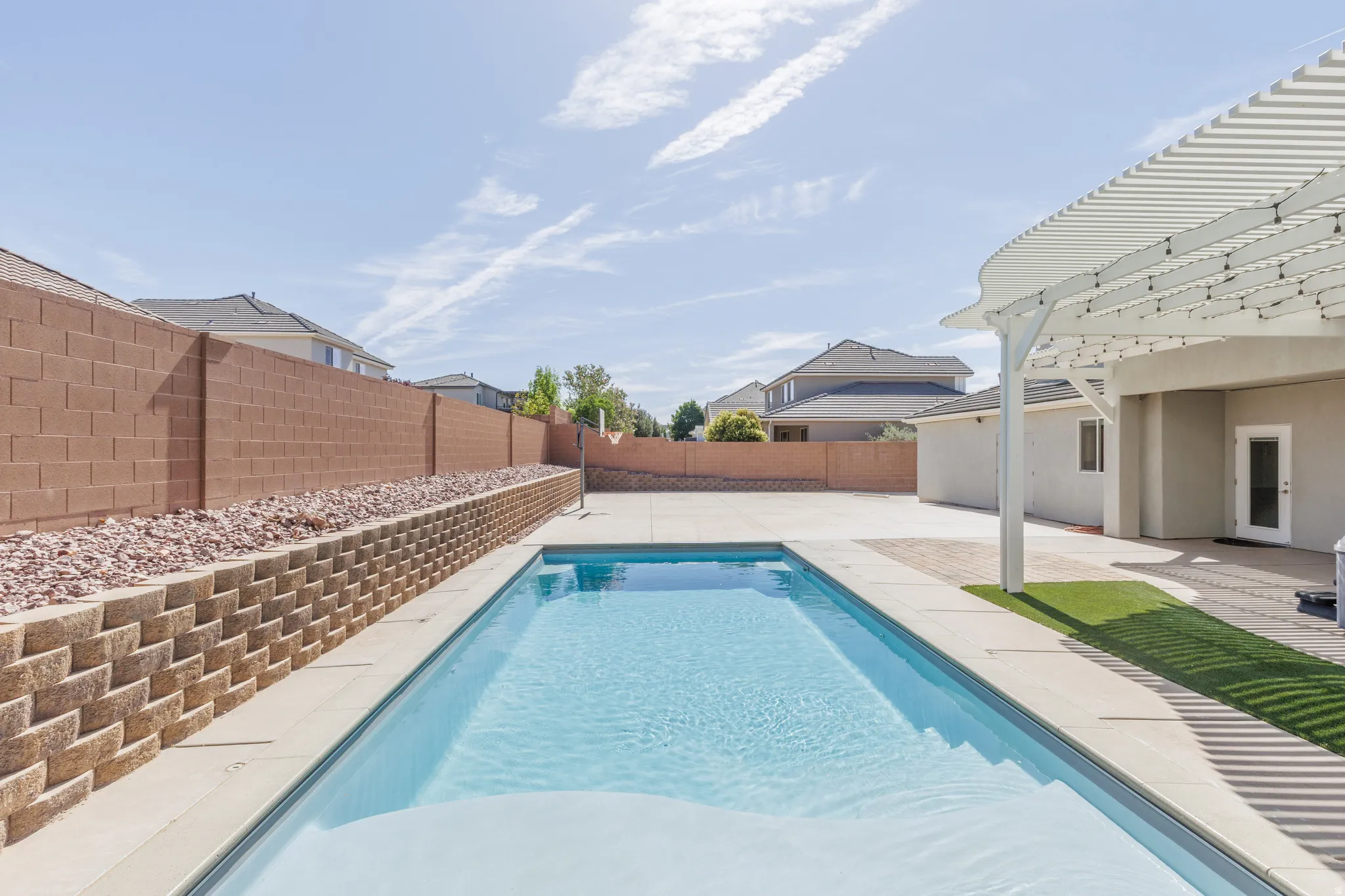 In-ground swimming pool with surrounding concrete decking