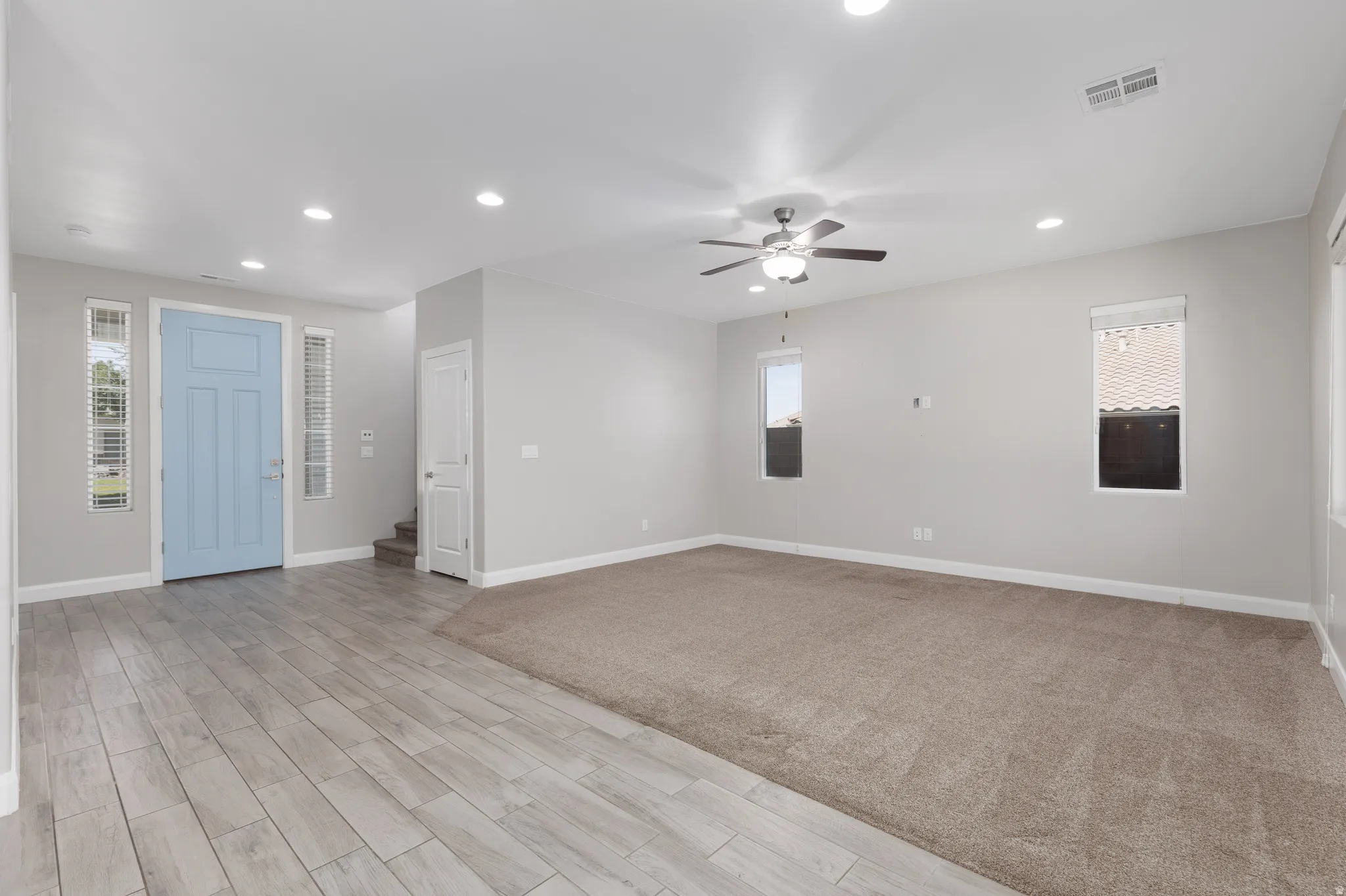 Spacious living area featuring wood-finish flooring, recessed lighting, and a ceiling fan