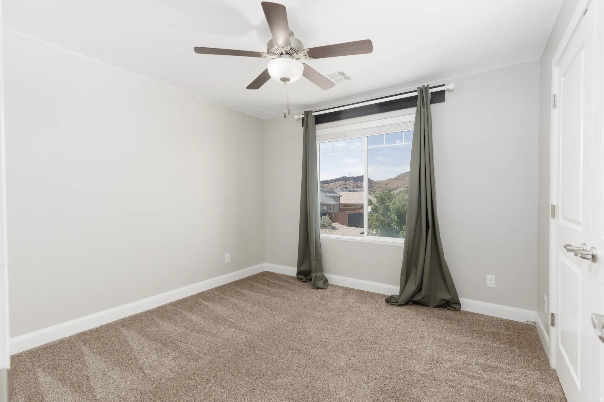 Neutral-toned interior room featuring light gray walls, plush brown carpet, and white trim