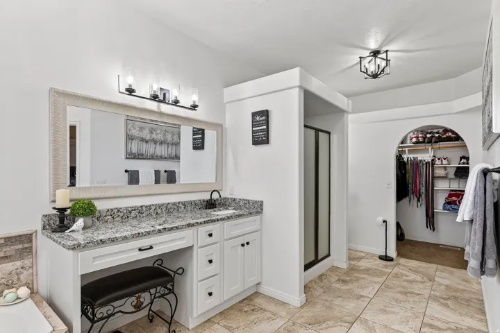 Double vanity with a granite countertop, undermount sink, and matte black faucet