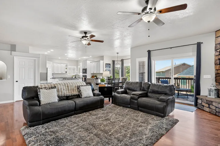 Open-concept living space featuring wood-finish flooring, recessed lighting, and multiple ceiling fans
