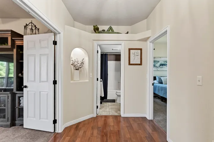 Hallway featuring wood-finish flooring and neutral wall tones