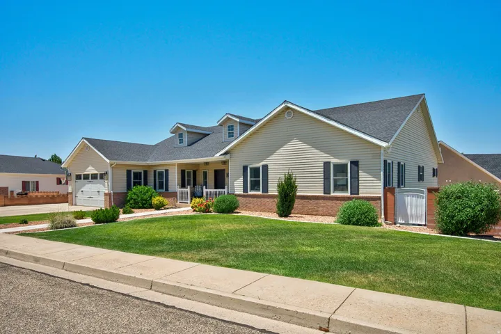 Ranch-style residence featuring beige siding, dark shingle roofing, and a brick base