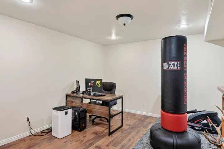 Versatile room with wood-finish flooring and recessed lighting