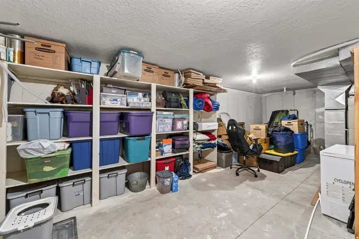Utility room featuring built-in shelving, concrete flooring, and exposed ductwork