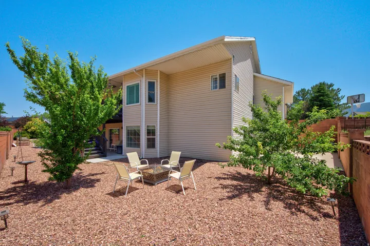 Exterior featuring beige siding, multiple windows, and a paved patio area