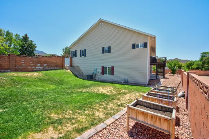 Rear exterior featuring light-colored vinyl siding and a raised deck with stairs