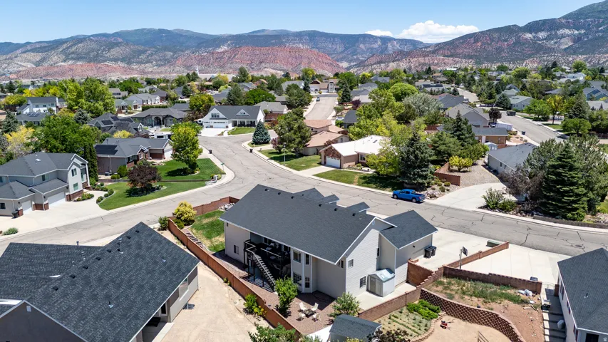 Aerial perspective showcasing a residential neighborhood with paved streets, mature landscaping, and varied rooflines
