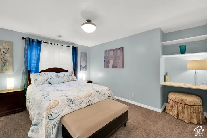 Bedroom featuring a built-in vanity nook with shelving, wood-finish flooring, and a flush-mount ceiling light