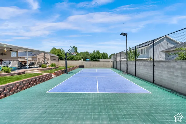 Multi-sport court featuring a basketball hoop and dedicated lighting