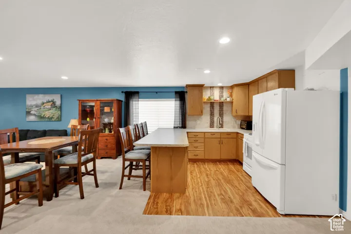 Kitchen and dining area featuring light wood-finish flooring, oak cabinetry, and a peninsula countertop