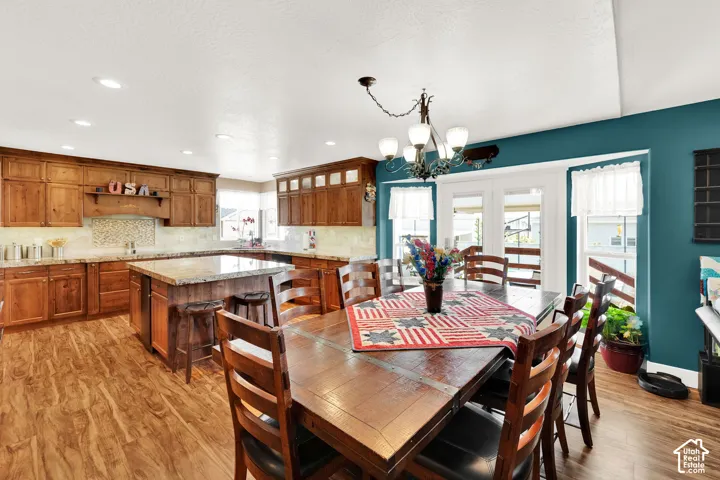 Kitchen and dining area featuring wood-finish flooring, recessed lighting, and a vaulted ceiling