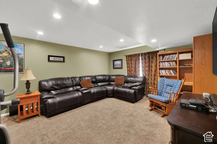 Spacious room featuring recessed lighting, soft green walls, and carpeting