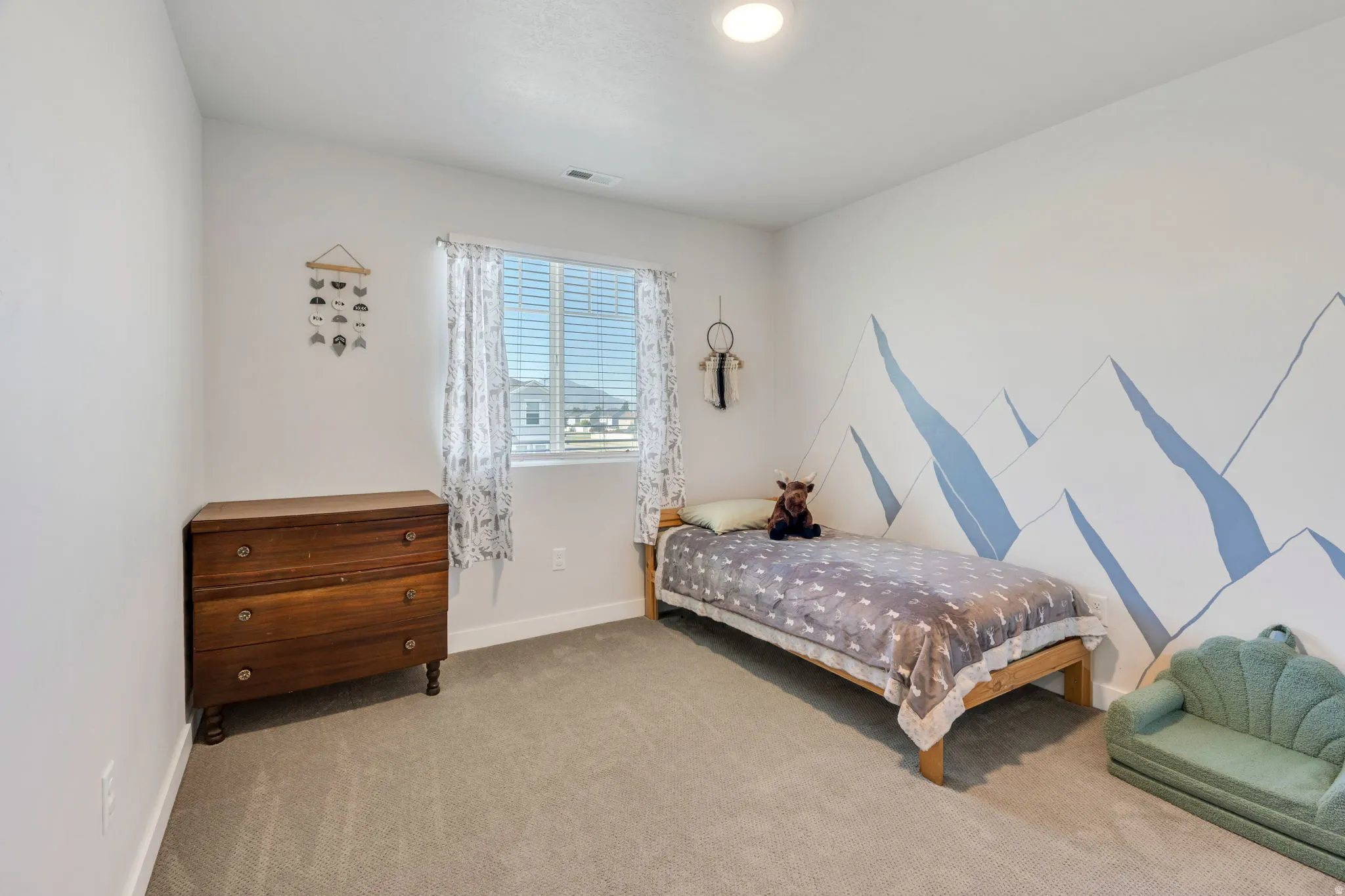 Neutral wall colors with a feature wall accent, recessed ceiling lighting, a window with blinds and patterned curtains, and neutral carpet flooring