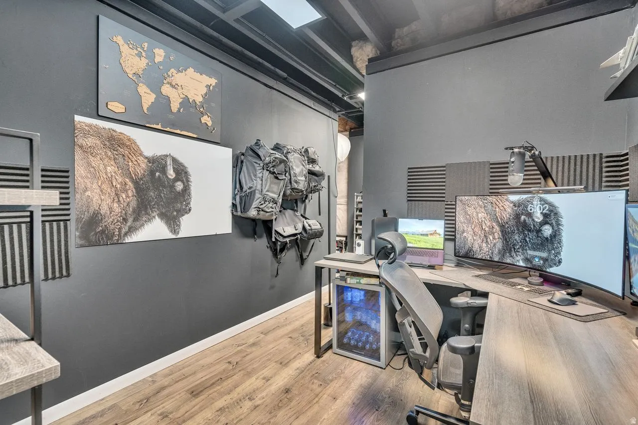 Dedicated workspace featuring wood-finish flooring and dark-toned walls